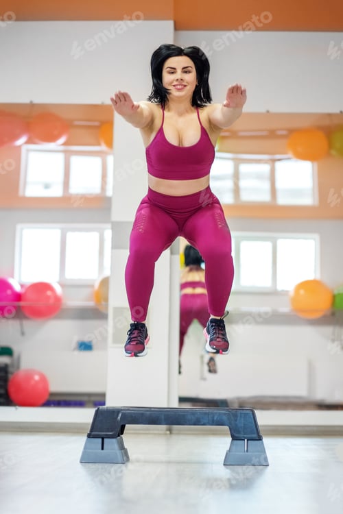 Preview: Athletic woman jumping on stepper. Exercise muscle. The concept of sports, a healthy lifestyle