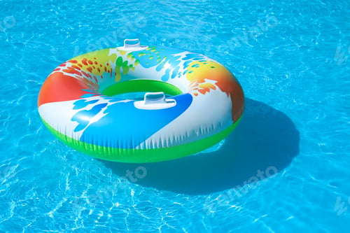 Preview: Colorful inflatable ring floating in swimming pool on sunny day