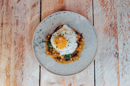 Preview: Plate with a fried egg on top of a bean stew.