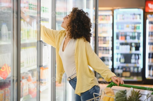 Preview: Customer choosing food from refrigerated section in supermarket
