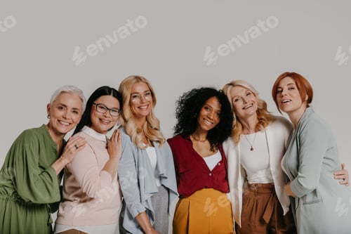Preview: Multi-ethnic group of elegant mature women bonding and smiling against grey background