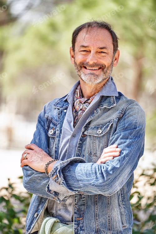 Preview: Bearded man smiling with arms crossed, looking at camera