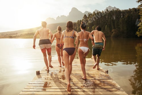 Preview: Young friends about to jump into the lake from a pier.