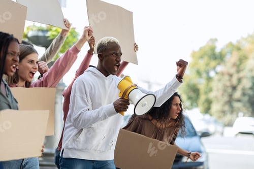 Preview: Side view of multiracial people with blank placards chanting slogans