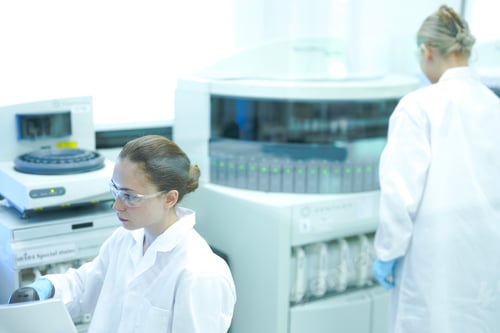 Preview: senior scientist mentors a junior colleague in a modern lab