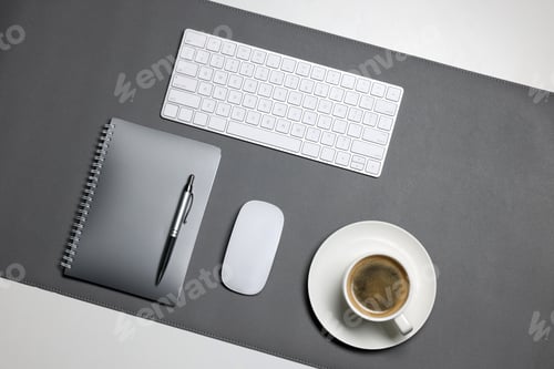 Preview: Grey mat, keyboard, mouse, notebook with pen and coffee on white desk, flat lay