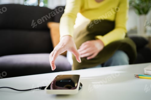 Preview: Charging mobile phone battery with wireless charging device in the table. Smartphone charging