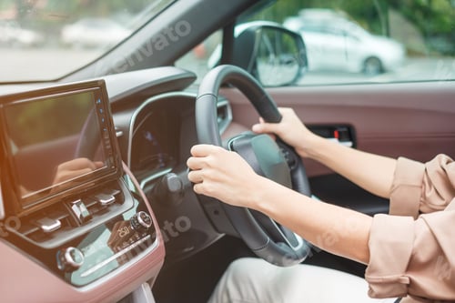 Preview: woman driver driving a car on the road, hand controlling steering wheel
