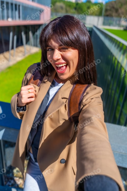 Preview: Happy university student winking at camera for selfie