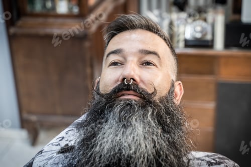 Preview: Stylish man sitting relaxed on a barbershop