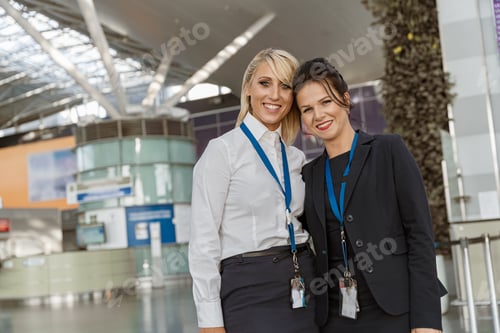 Preview: Portrait of smiling female airport employees at their workplace in terminal looking camera