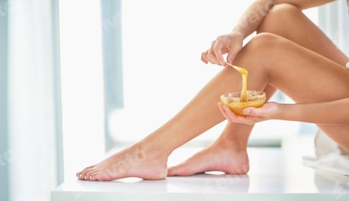 Preview: Cropped shot of an unrecognizable woman applying wax to her legs in the bathroom at home