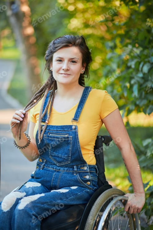 Preview: stylish attractive hipster girl sitting on wheelchair looking at the camera