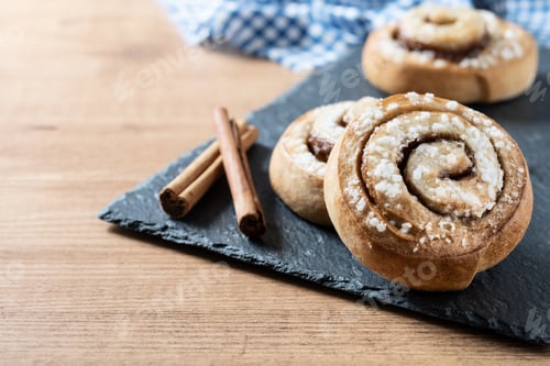 Preview: Cinnamon rolls buns on wooden table. Kanelbulle Swedish dessert