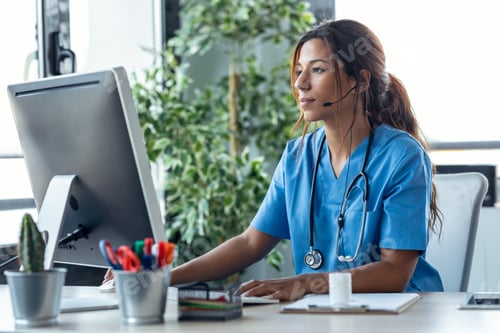 Preview: Female doctor with earphone while explaining medical treatment to patient through a video call