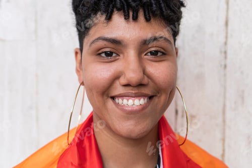 Preview: Young latin american woman smiling and showing pride with lgbt flag