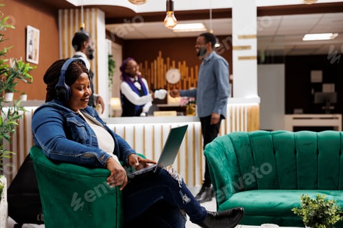 Preview: Woman resting in hotel lobby with laptop