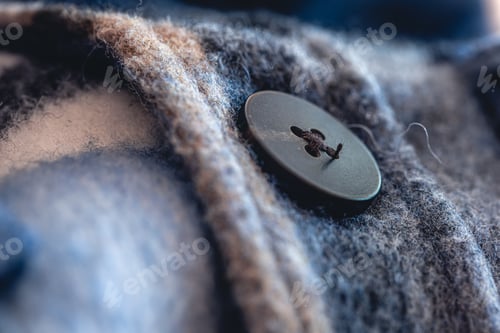 Preview: Button on a warm blue shirt, macro shot.