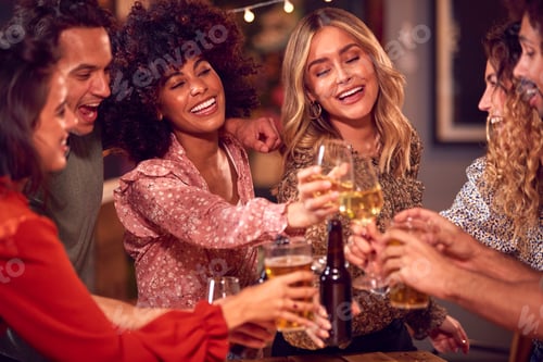 Preview: Multi-Cultural Group Of Friends Enjoying Night Out Drinking In Bar Together Making A Toast