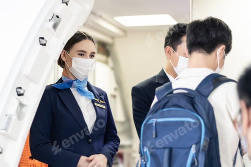 Preview: Asian flight attendants wearing face mask greeting passengers coming in airplane during the Covid.