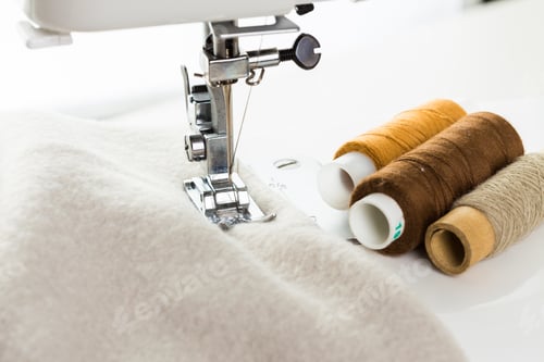 Preview: Sewing machine with colorful threads on a soft fabric during a creative project