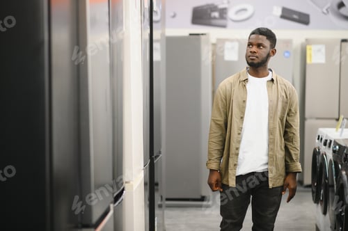 Preview: Man choosing fridge in the shop