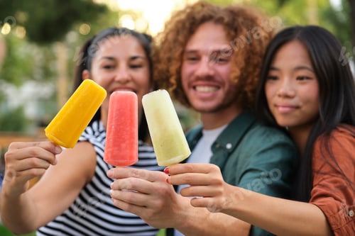 Preview: Three friends showing colorful ice cream bars in a park