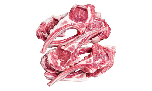 Vista previa: Filetes de cordero crudos, chuletas de carne fresca en la mesa de carnicería. Fondo blanco aislado.