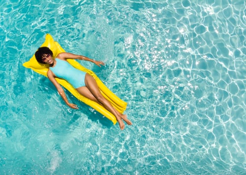 Preview: Young biracial woman enjoys a relaxing day on a pool float, with copy space