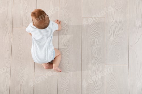 Preview: Cute baby crawling on floor, top view. Space for text