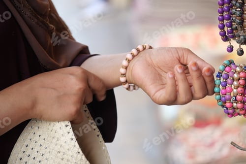 Preview: Woman selecting colorful bracelets in a marketplace