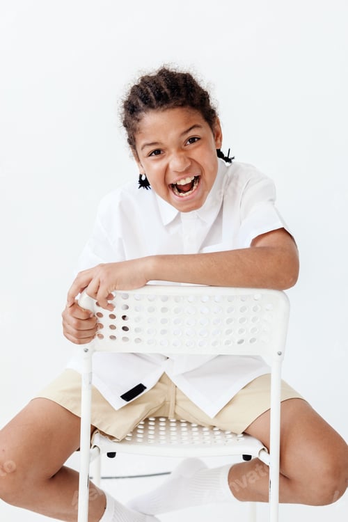 Visualização: Jovem confiante sentado na cadeira com as mãos nos quadris, exalando uma atitude moderna e elegante