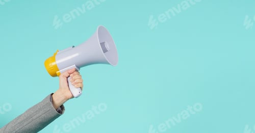Preview: Hand is hold megaphone and wear grey suit on green or mint or Tiffany Blue background.