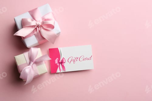 Preview: Gift card and presents on pink background, flat lay. Space for text