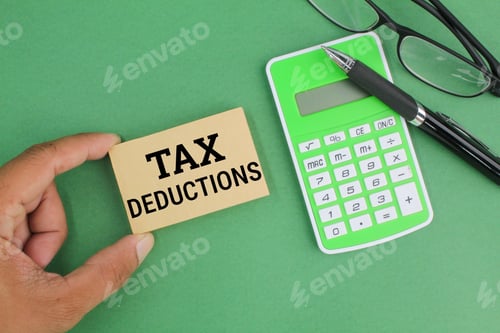 Preview: pen, calculator, glasses and paper with the word Tax Deductions.