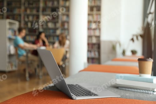Preview: Laptop on bench in library. Space for text
