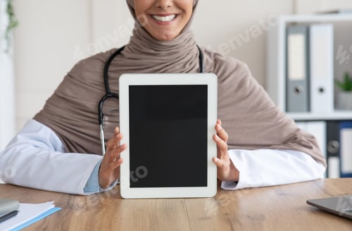 Preview: Cropped of female doctor showing digital tablet with blank screen