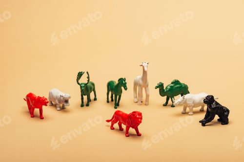 Preview: Red lion with colored toy animals on yellow background, extinction of animals concept