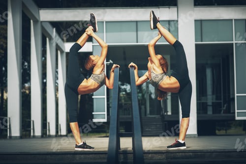 Preview: Two twins sisters stretching outdoor
