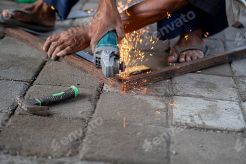 Preview: Worker using angle grinder to cut metal