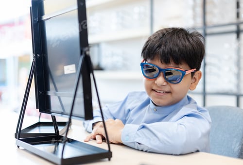 Preview: Happy Indian child boy wearing sunglasses in glasses shop.