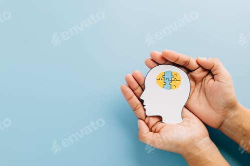 Preview: Down Syndrome Day celebrates awareness with hands holding a brain jigsaw in a head cutout.