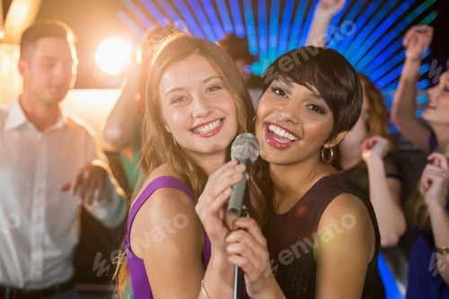 Preview: Portrait Of Two Beautiful Women Singing Song Together In Bar