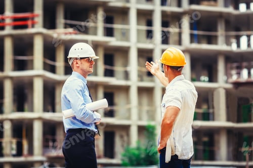Preview: Architect and builder discussing at construction site