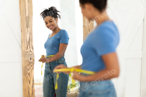 Preview: Cheerful Black Lady After Weight-Loss Measuring Waist With Tape Indoors