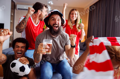 Enthusiastic Adults Celebrating Victory at Home with Beer