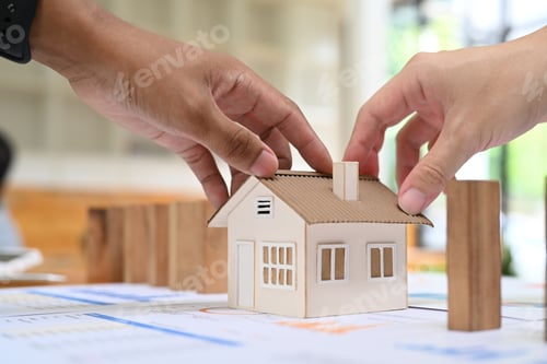 Preview: Cropped imaged of young couple holding. house model. Real estate investment, purchase and sale.