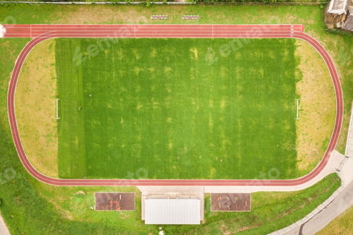 Preview: Aerial view of sports stadium with red running tracks and green grass football field