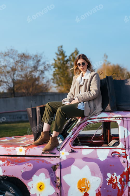 Preview: Young woman sits on an old decorated car