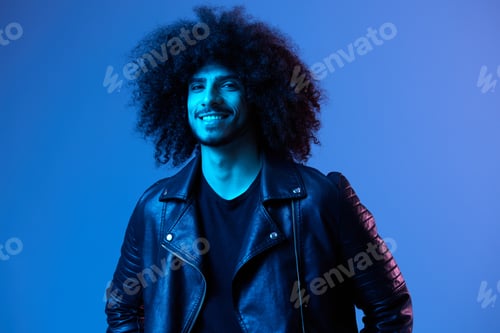 Preview: Portrait of fashion man with curly hair on blue background multinational, colored light, black
